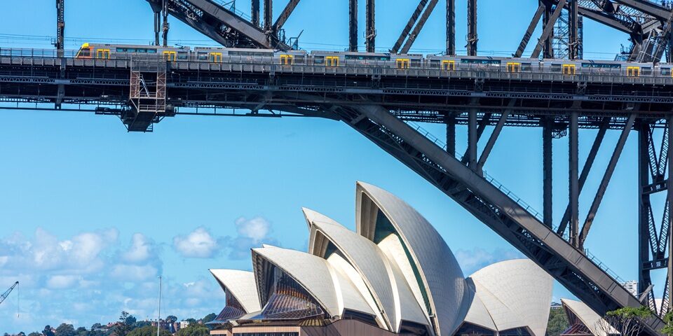 HYY3DA Sydney train travelling across Sydney harbour bridge with opera house in background,Australia